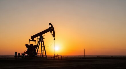 Industrial growth concept with silhouette of pumpjack at sunrise.
