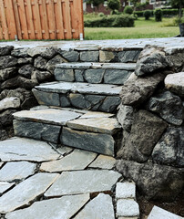 Grey tiled steps in rectangular pattern, showing texture, structure, and shadow under natural light.