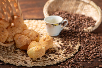 Cheese bread and coffee, delicious Brazilian cheese bread and a beautiful cup of coffee on a rustic table and coffee beans, abstract background, selective focus.