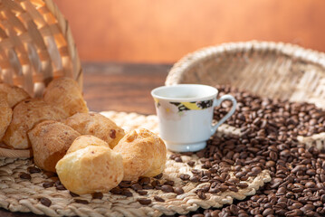 Cheese bread and coffee, delicious Brazilian cheese bread and a beautiful cup of coffee on a rustic table and coffee beans, abstract background, selective focus.
