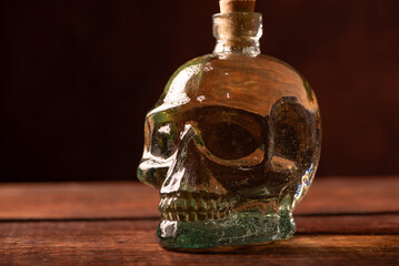 Cachaça bottle, details of a Brazilian cachaça bottle in the shape of a skull, low key photo, selective focus.