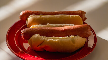 Two Plain Hot Dogs on a Red Plate