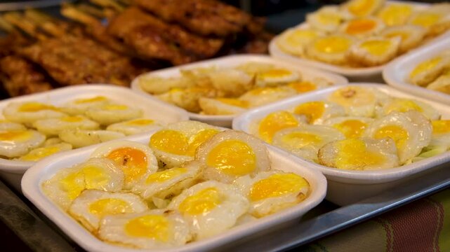 Quail Egg Skewers being cooked at Shilin Night Market, Taipei, Taiwan. Taiwanese street food. Low angle, parallax movement, slow motion, HD.