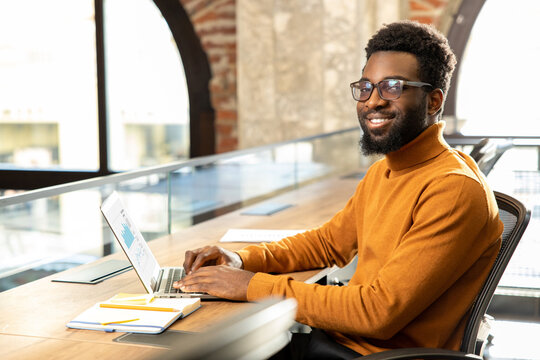 African american young man with laptop working in the office