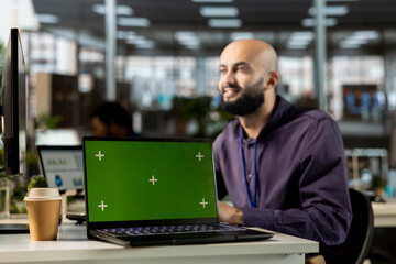 Fototapeta premium Middle eastern general manager sitting at desk next to green screen on pc, examining analytics in order to create a financial report for the investors group. Looking for enterprise solutions.
