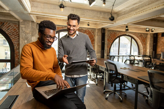 Colleagues working together in the office and looking contented