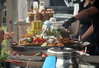Outdoor Food Stall: Chef Prepares Fresh Meals at Bustling Market - Culinary Activity: Close-Up of Busy Hands Cooking and Serving Street Food