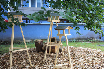 Fototapeta premium Wooden bird feeder hanging on a tree branch.