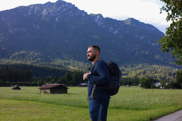 A  man is hiking in the mountains with a backpack. 