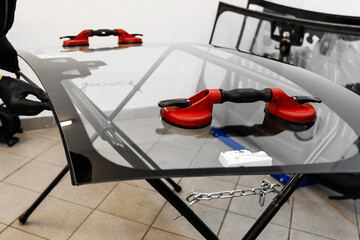 Inspecting the windshield edge before applying adhesive for seamless car glass installation. Windshield Edge Sealing Preparation. Technician prepares car windshield edge for installation.