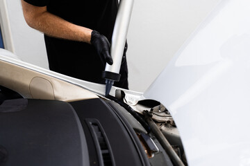 Applying adhesive to a car windshield using a caulking gun. Urethane caulking gun applies flexible...