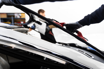 Windshield Installation Using Suction Lifters. Two technicians install windshield using suction...