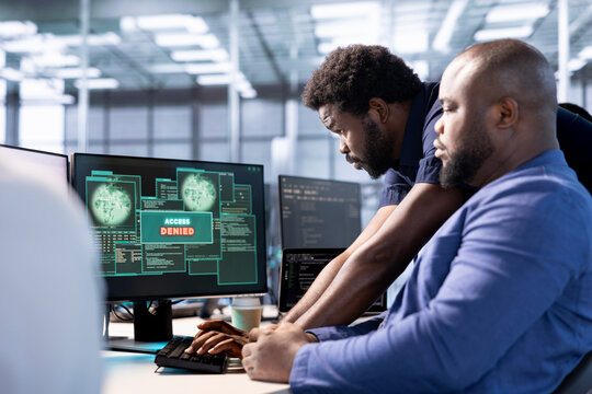 Employee requesting help from manager after receiving access denied popup notification while trying to optimize server hub. Data center manager assisting worker failing to eliminate network errors