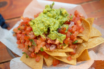 Another order of tortilla chips with guacamole and salsa served at an outdoor table at a taqueria in Burlingame, CA, on May 8, 2021