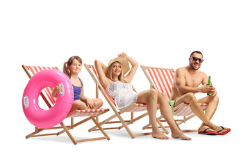 Mother, father and daughter sunbathing on deck chairs