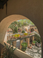 View through arch of sunlit courtyard with flowers in Sedona, Arizona