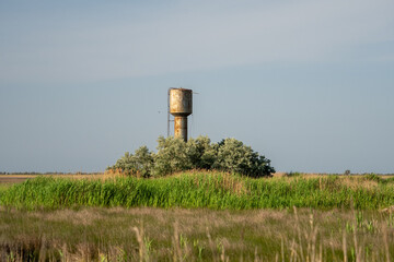 Rusty water tower in wild grassland on Dzharylhach Island, Ukraine