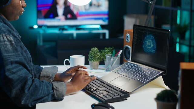 Data scientist using laptop, updating artificial intelligence machine learning algorithms, writing code scripts. Teleworking IT specialist in apartment office uses programming to upgrade AI, camera A - Powered by Adobe