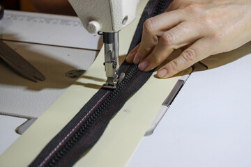 Sewing on a zipper on a sewing machine © Oleksandr