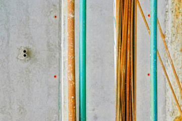 Rusty reinforcement bars rest on scaffolding at a construction site