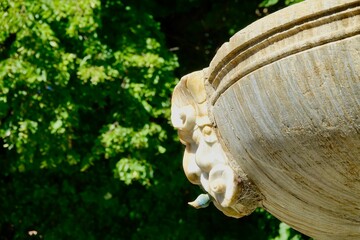 Detail of a marble mask in the bowl of the Los Gigantones fountain in Bib-Rambla square in Granada (Spain)