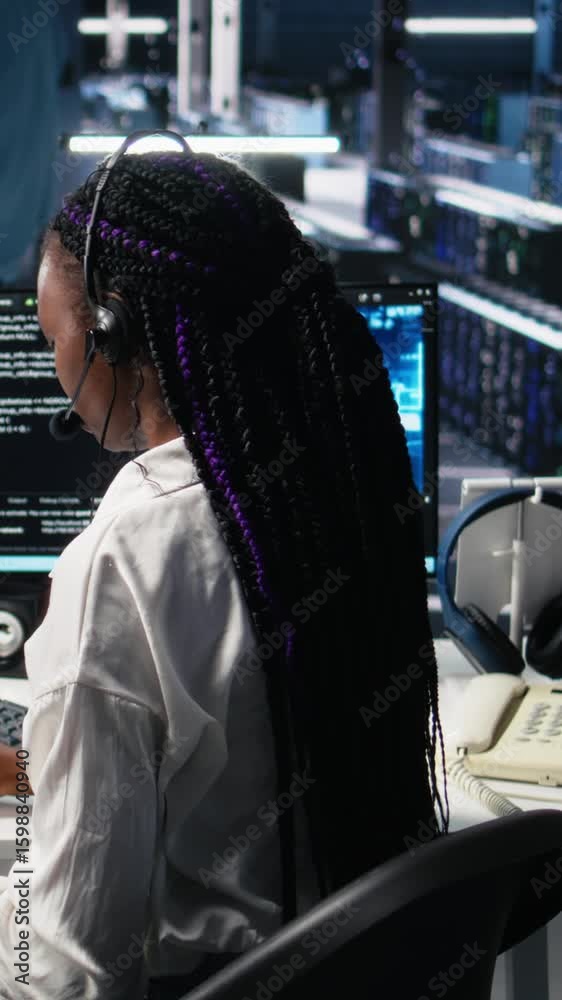 Poster vertical video system administrator in data center wearing headset assisting users with artificial i