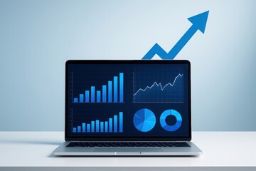 Laptop displaying financial charts and graphs with a blue upward trending arrow symbolizing growth and success