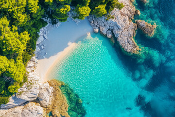 Aerial drone view of a hidden cove on Krk Island, Croatia - crystal clear water, pine trees, stone beach, vibrant colors