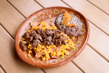 Scrambled eggs with ham, beef steak and beans