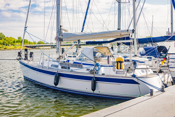 White sailing yacht moored at pier on sunny day