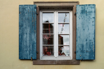 Fenster mit blauen Fensterläden und Spiegelungen