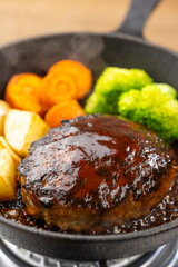 熱々のデミグラスソースハンバーグをスキレットで調理