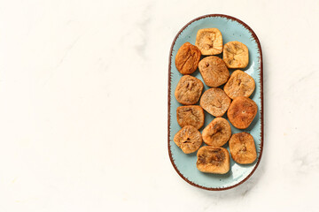 Plate with sweet dried figs on white background