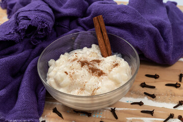 Typical brazilian dish hominy canjica with cinnamon in pot in wood table