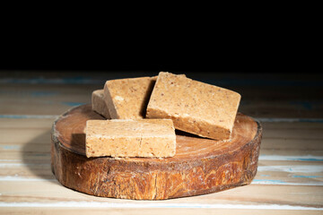 Wooden cutting board with sweets made from peanuts known in brazil as pacoca.