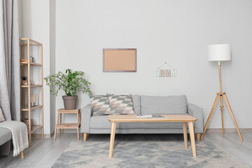 Modern interior of living room with sofa and table near light wall