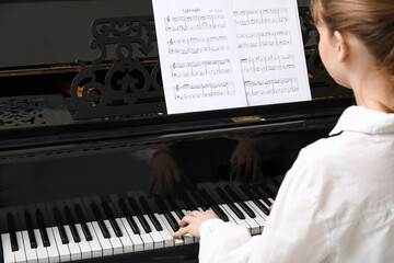 Young woman playing piano, closeup