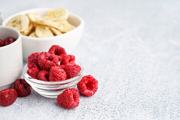Bowls with tasty freeze-dried fruits on light background