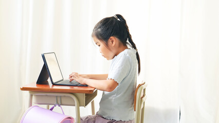 教室でノートパソコンを使う女の子