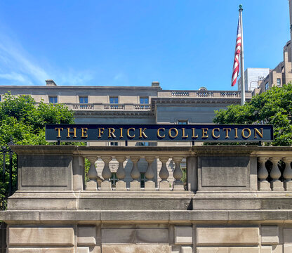New York, NY - US - Jul 6 2025 The Frick Collection&rsquo;s bold sign stands above a stone balustrade, backed by manicured trees and its elegant limestone mansion under a bright summer sky and U.S. flag.