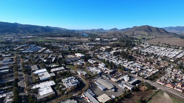 A daytime summer aerial establishing shot of San Luis Obispo in southern California. Helicopter GoPro footage. Longer segments available upon request. The 101 / Cabrillo Highway below.  	