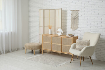 Interior of modern room with folding screen, armchair and chest of drawers