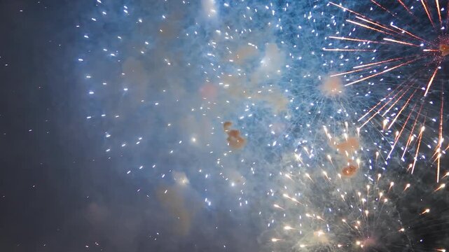 Fireworks exploding in slow motion with vibrant colors and glowing sparks