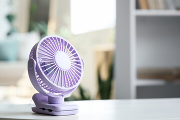 Small electric fan on table in room