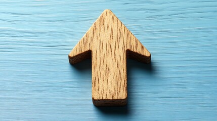 Light brown wooden upward pointing arrow on light blue wooden surface.