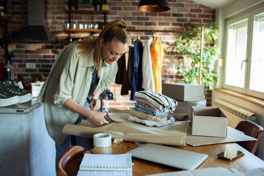Young woman working on online boutique small business from home office