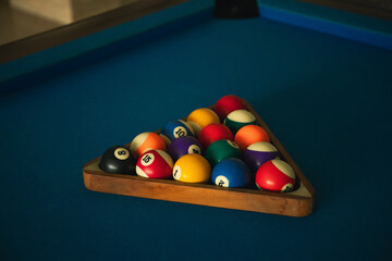 Brightly colored billiard balls set for a game on a blue table