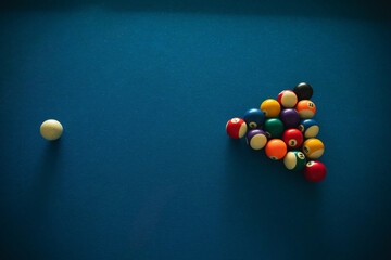 A white cue ball positioned near a triangle of billiard balls