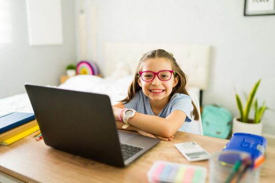 Smiling girl learning with laptop at home for remote education