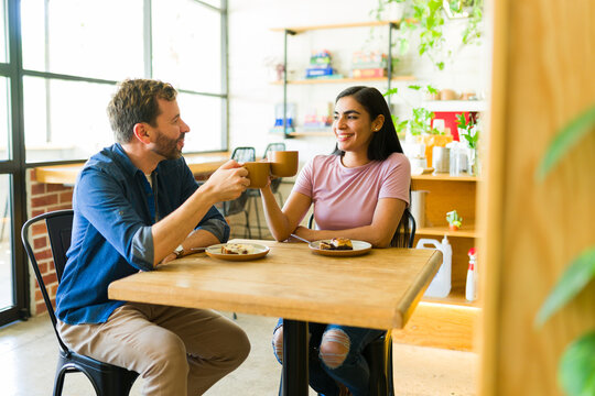 Cute couple making a toast with coffee during a date - Powered by Adobe